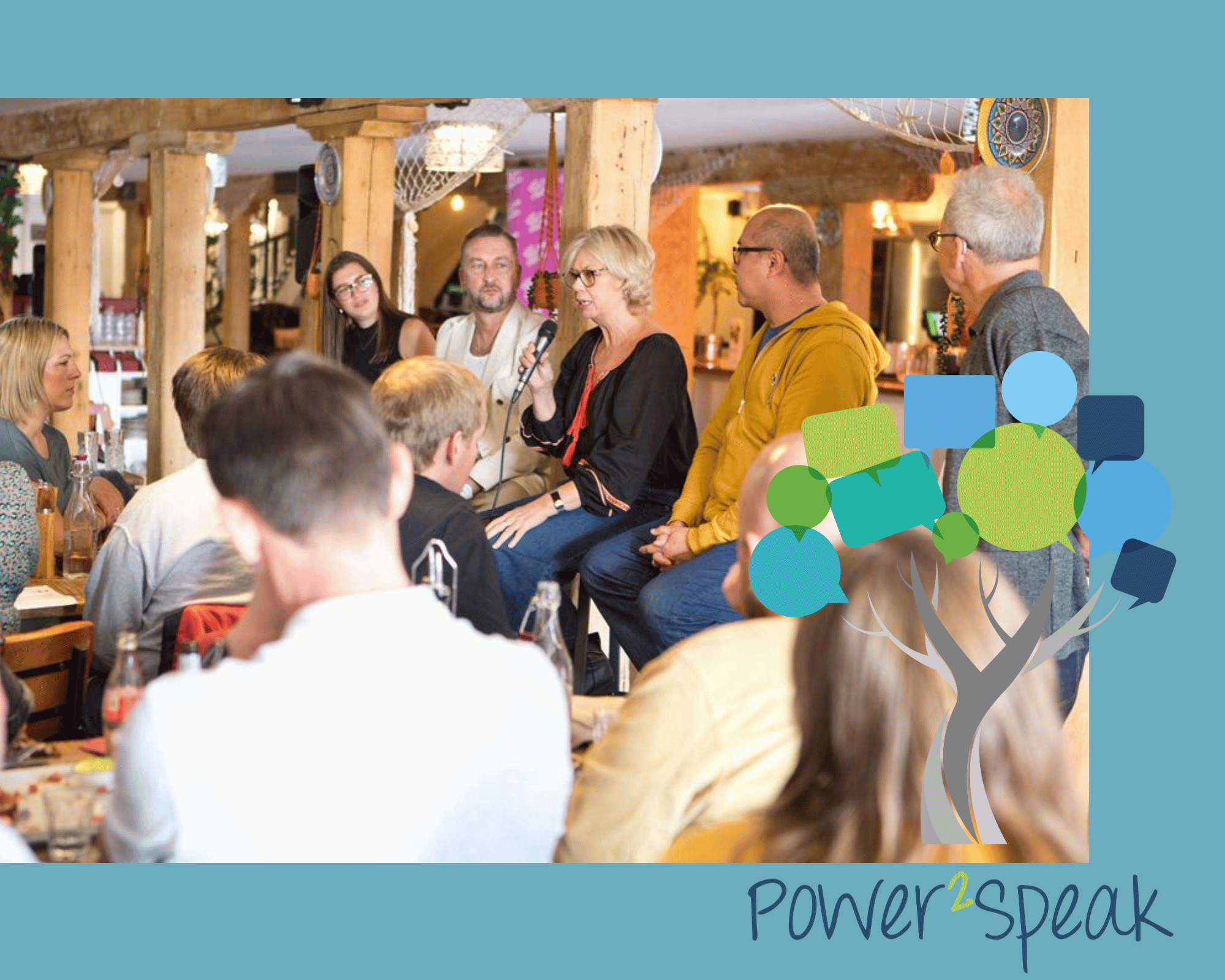 Jackie speaking into a mic on a panel for a YATM lunch club. Diners are watching